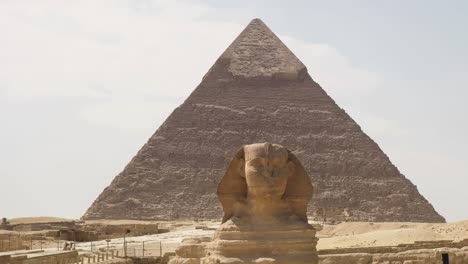 Die-Ikonische-Sphinx-Mit-Der-Majestätischen-Kulisse-Der-Großen-Pyramiden-Von-Gizeh-Ist-Eine-Beeindruckende-Szene,-Die-Ägyptens-Zeitlose-Erhabenheit-Und-Monumentales-Erbe-Verkörpert