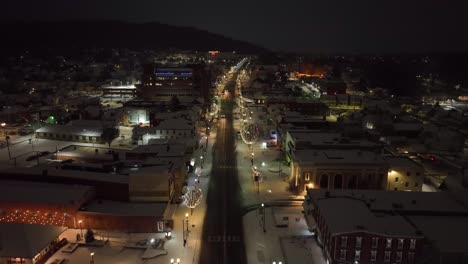 Ciudad-Cubierta-De-Nieve-Con-Adornos-Navideños-Por-La-Noche.