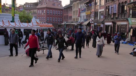 Amplia-Vista-A-Nivel-Del-Suelo-De-Personas-Caminando-Por-La-Sección-Exterior-Del-Templo-Boudhanath,-Katmandú,-Nepal