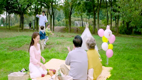 Familia-Feliz-De-Varias-Generaciones-Haciendo-Un-Picnic-Pasatiempo-Juntos-Equipo