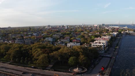 Aerial-low-panning-shot-of-White-Point-Garden-at-the-tip-of-South-Battery-during-sunset-in-Charleston,-South-Carolina