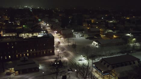 Aerial-footage-through-the-small-town-of-Lititz-PA-on-a-snowy-winter-evening,-looking-north