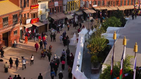 Toma-Medianamente-Elevada-De-Personas-Caminando-Por-La-Sección-Exterior-Del-Templo-Boudhanath,-Katmandú,-Nepal.