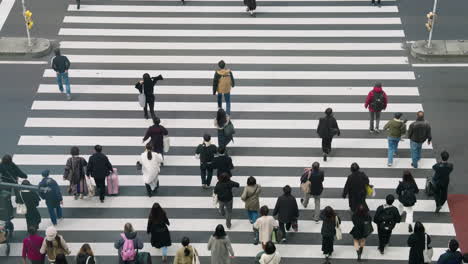 Pedestrians-Walking-At-Zebra-Crossing-In-Shibuya-City,-Tokyo,-Japan