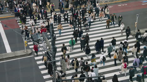 High-Angle-Shot-Of-People-Crossing-On-Pedestrian-Crosswalk-Near-Shinjuku-Expressway-Bus-Terminal-In-Shibuya,-Tokyo,-Japan