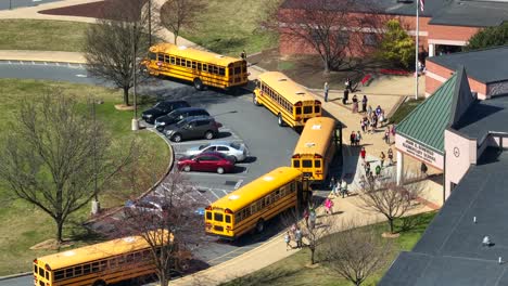 Aerial-top-down:-Kids-and-children-from-school-walking-to-yellow-school-buses