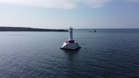 Drone-orbits-lighthouse-on-body-of-water