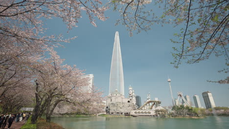 Seokchon-Lake-Park-And-Lotte-World-Tower-With-Sakura-Blooming-Flowers-In-Seoul,-South-Korea