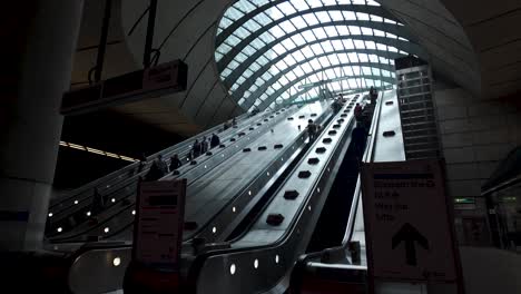 Personen,-Die-Auf-Rolltreppen-In-Der-Geschäftigen-U-Bahnstation-Canary-Wharf-In-London-Pendeln,-Veranschaulichen-Das-Konzept-Der-Städtischen-Mobilität-Und-Der-Anbindung-An-Großstädte