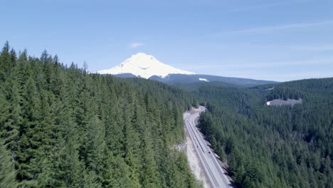 Drone-shot-pushes-in-above-high-tree-line,-focusing-directly-on-Mount-Bachelor