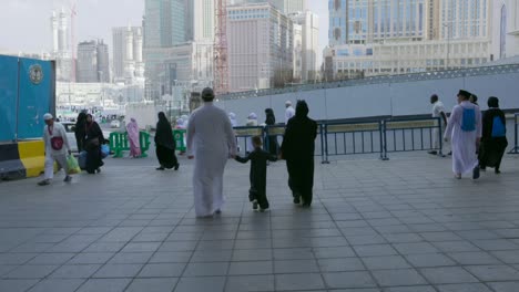 The-Clock-Towers-Hotel-With-Crowded-People-Walking-On-The-City-Streets-In-Mecca,-Saudi-Arabia