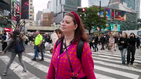 Eine-Frau-Läuft-Durch-Die-Menschenmenge-Auf-Der-Shibuya-Kreuzung-In-Tokio,-Japan