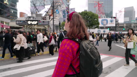 Mujer-Con-Mochila-Caminando-En-El-Cruce-De-Shibuya-En-Tokio,-Japón