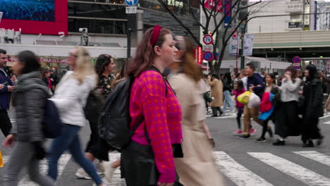 Frau-Mit-Rucksack-Auf-Der-Belebten-Straße-Shibuya-Crossing-In-Shibuya,-Tokio,-Japan