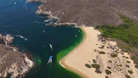 Drone-view-of-Cacaluta-beach-with-green-colors-and-calm-waters-in-Huatulco,-Oaxaca