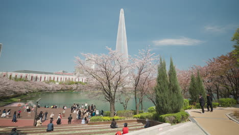 Plataforma-De-Observación-Frente-Al-Lago-En-El-Parque-Del-Lago-Seokchon-Con-La-Torre-Lotte-World-Al-Fondo-En-Seúl,-Corea-Del-Sur