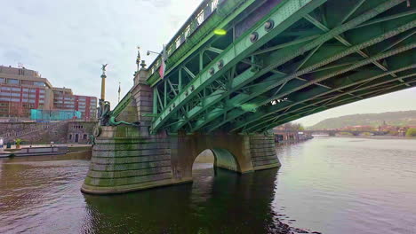 Sliding-shot-under-a-steel-bridge-suspended-over-a-river-in-Europe