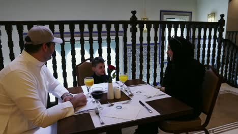 Modern-Muslim-family-enjoying-breakfast-at-a-restaurant-in-Mecca,-Saudi-Arabia