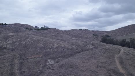 Drone-ascends-hill,-revealing-small-church-atop