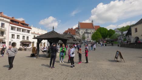 Gente-Alrededor-Del-Pozo-Histórico-En-La-Plaza-Del-Mercado-De-Kazimierz-Dolny-En-Polonia