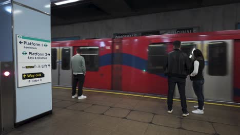 Commuters-Waiting-For-DLR-Arriving-At-Cutty-Sark-Station-Platform