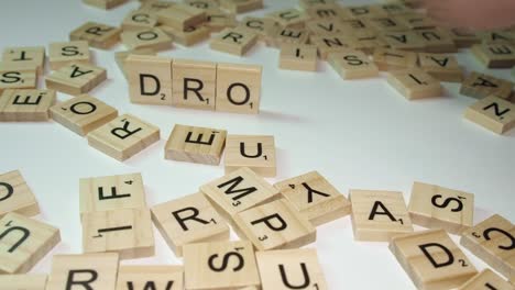 Scrabble-Buchstabensteine-Bilden-Das-Wort-„Drone“-Inmitten-Verschiedener-Steine-Auf-Dem-Tisch