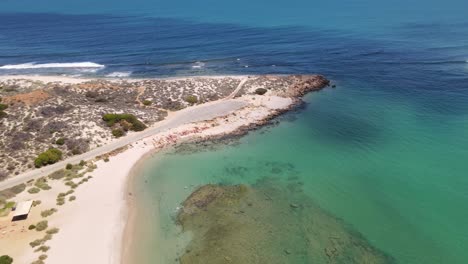 Drohnenluftaufnahme-Einer-Lagune-Mit-Leuchtend-Blauem-Wasser-Und-Dem-Ozean-Mit-Dunkelblauem-Wasser