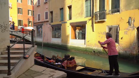 Gondolier-sails-on-gondola-with-two-tourists-who-takes-pictures-of-themselves