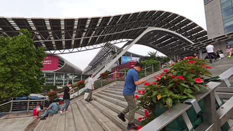 Foreign-visitor-to-Canton-fair-sit-on-the-stairs-of-exhibition-complex,-Guangzhou,-China