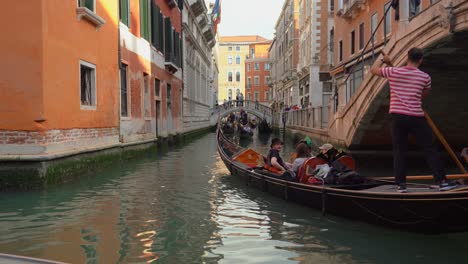 Junger-Venezianischer-Gondoliere-In-Venedig-Segelt-Eine-Gruppe-Von-Touristen-Im-Wasserkanal