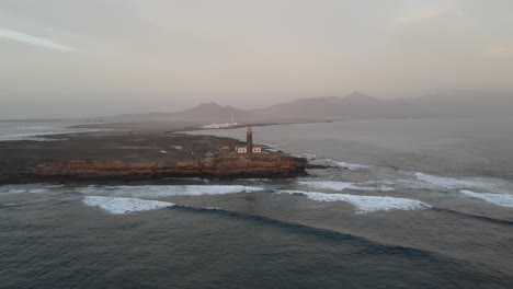 Aerial-footage-showcases-the-elegance-of-a-lighthouse-standing-tall-on-a-cliff—a-coastal-beauty-that-is-both-timeless-and-enchanting,-offering-a-moment-of-respite-and-reflection