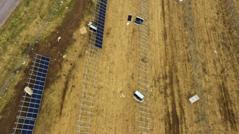 Antena-Arriba-Hacia-Abajo-De-La-Construcción-De-Una-Gran-Granja-De-Paneles-Solares-Con-Rejillas-Y-Unidades-En-El-Campo