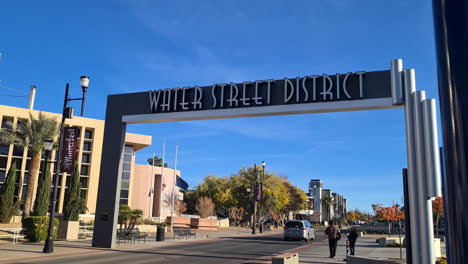 Henderson-NV-USA,-Water-Street-District-Entrance-Gate,-City-Center-Traffic-on-Hot-Sunny-Day