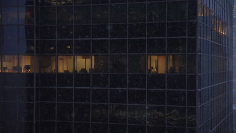 close-up-establishing-shot-of-urban-high-rise-office-building-windows-during-a-snow-storm