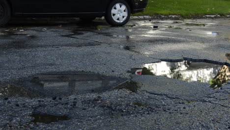 Car-hits-pothole-in-road,-splashes-water