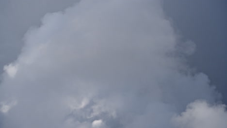 Timelapse-of-blooming-white-clouds-in-sky,-telephoto-upward-view