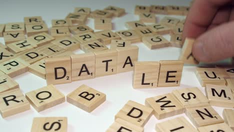 Words-DATA-and-LEAK-formed-from-Scrabble-letter-tiles-on-table-top