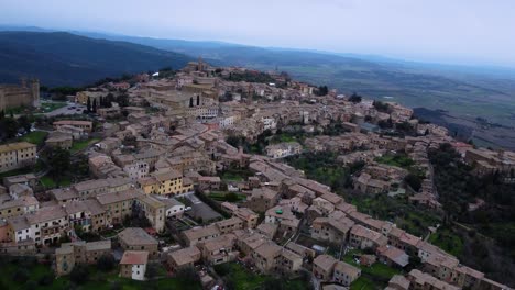 Aerial-view-of-medieval-city-Montalcino-in-Italy,-historic-fortress,-old-town-reveal