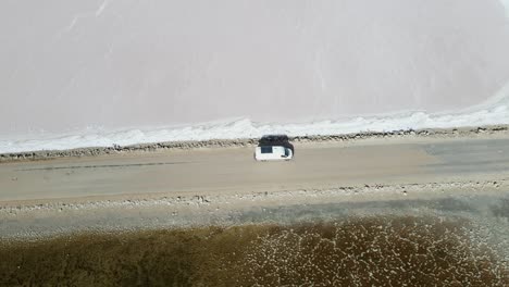 Avión-Teledirigido-Sobre-Autocaravana-Conduciendo-Lentamente-Por-La-Carretera-Sobre-El-Lago-Rosa-Macdonnell-En-El-Sur-De-Australia