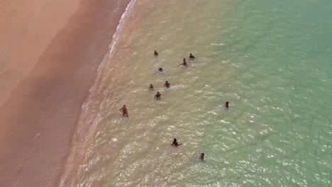 Aerial-topdown-African-kids-having-fun-in-turquoise-colored-water,-São-Tomé-e-Principe-Island