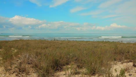 Shot-of-waves-crashing-along-the-sandy-beach-of-French-Atlantic-coast-on-a-sunny-day