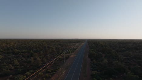 Clip-De-Drone-Que-Muestra-Un-Largo-Camino-Recto-A-Través-Del-Desierto-Del-Interior-De-Australia-Hacia-El-Horizonte