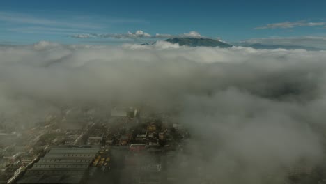 Drohne-Fliegt-über-Machachi-Stadt-Mit-Dichter-Niedriger-Kondensation,-Die-Die-Stadt-Verbirgt