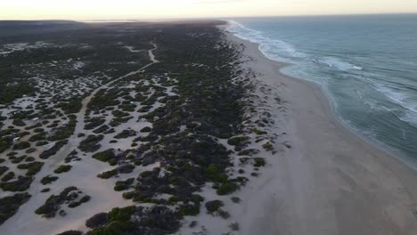 Drone-aerial-high-over-a-quiet-pristine-beach-during-sunrise