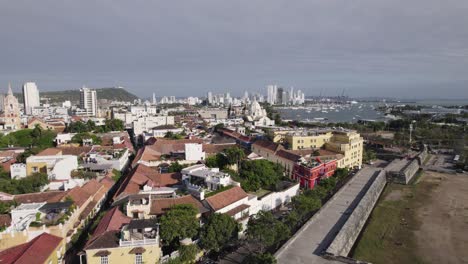 Panoramic-aerial-pan-across-Cartagena-Colombia-yellow-building-facades-by-the-ocean