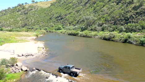 Imágenes-De-Drones-De-Una-Ute-Conduciendo-A-Través-Del-Río-Murrumbidgee-En-Un-Cruce-En-ángulo-En-El-Territorio-De-La-Capital-Australiana.