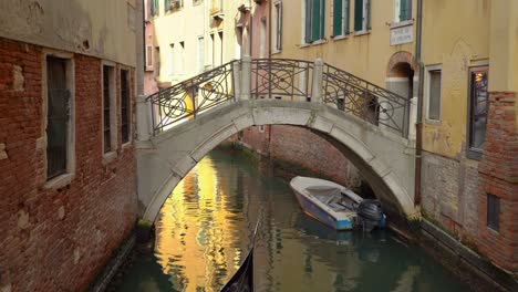 Gondolier-with-gondola-sails-an-elderly-couple-in-one-of-many-water-canals-in-Venice
