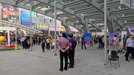 Foreign-visitor-buyers-walk-between-exhibition-area-inside-Canton-fair-Complex,-Guangzhou,-China