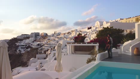 Romantisches-Paar-Genießt-Den-Sonnenuntergang-Am-Pool-In-Santorini,-Griechenland