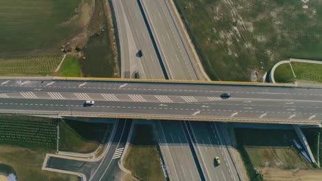 Aerial-drone-top-down-view-of-highway-multi-level-road-with-moving-cars-at-sunset